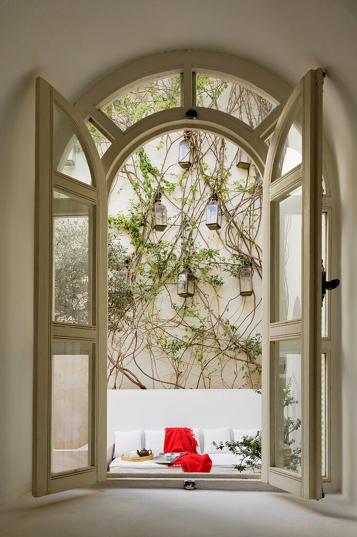 View of inner courtyard with climbing plants, lanterns and seating area