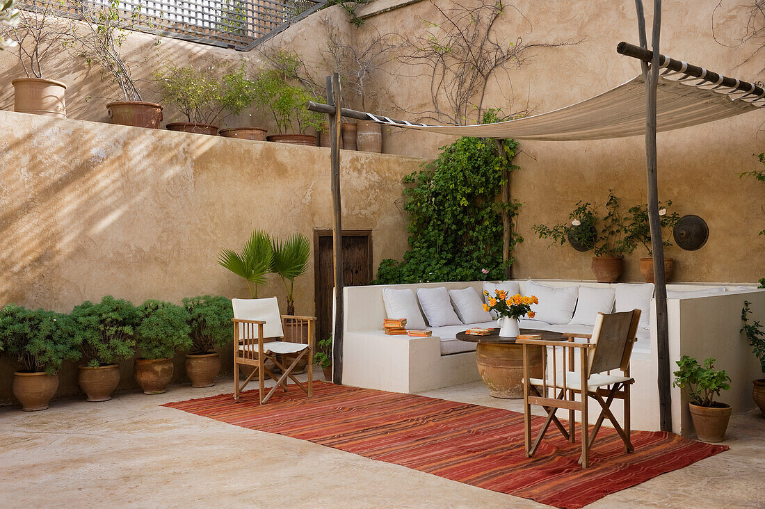 Patio with seating area, modern wooden chairs and potted plants