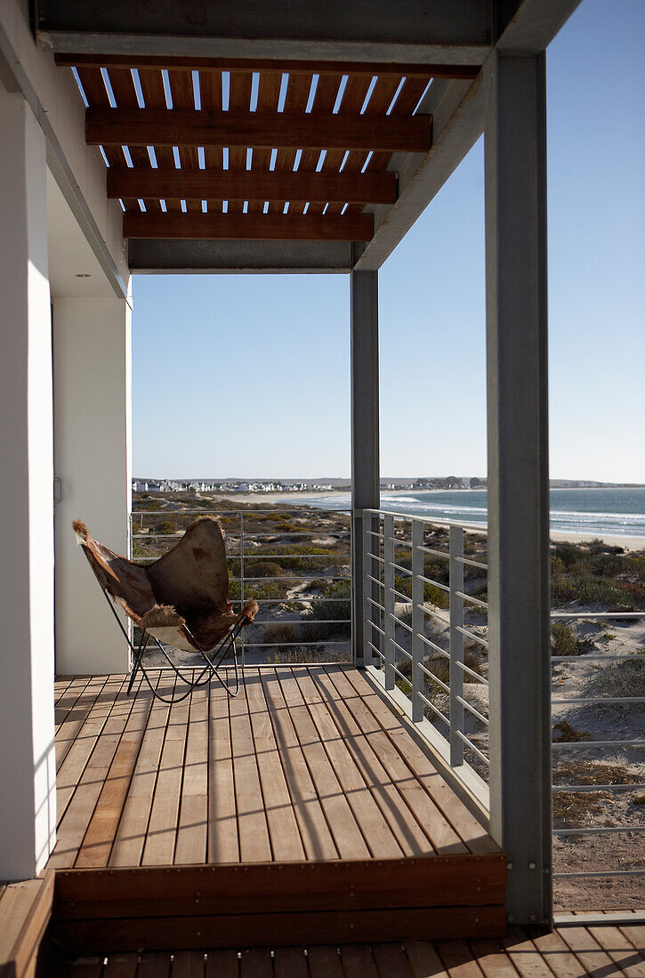 Balcony with wooden floor and steel construction, view of dune landscape