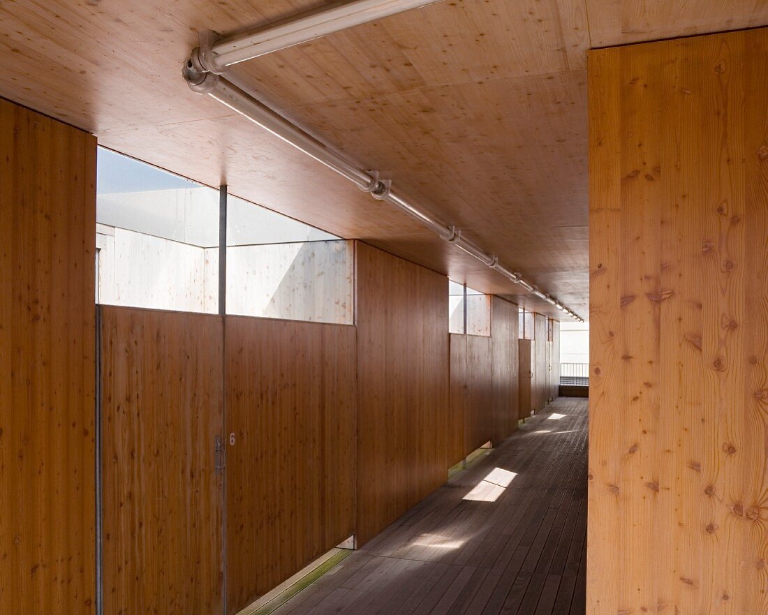 Wood-clad hallway with transom windows in wooden wall
