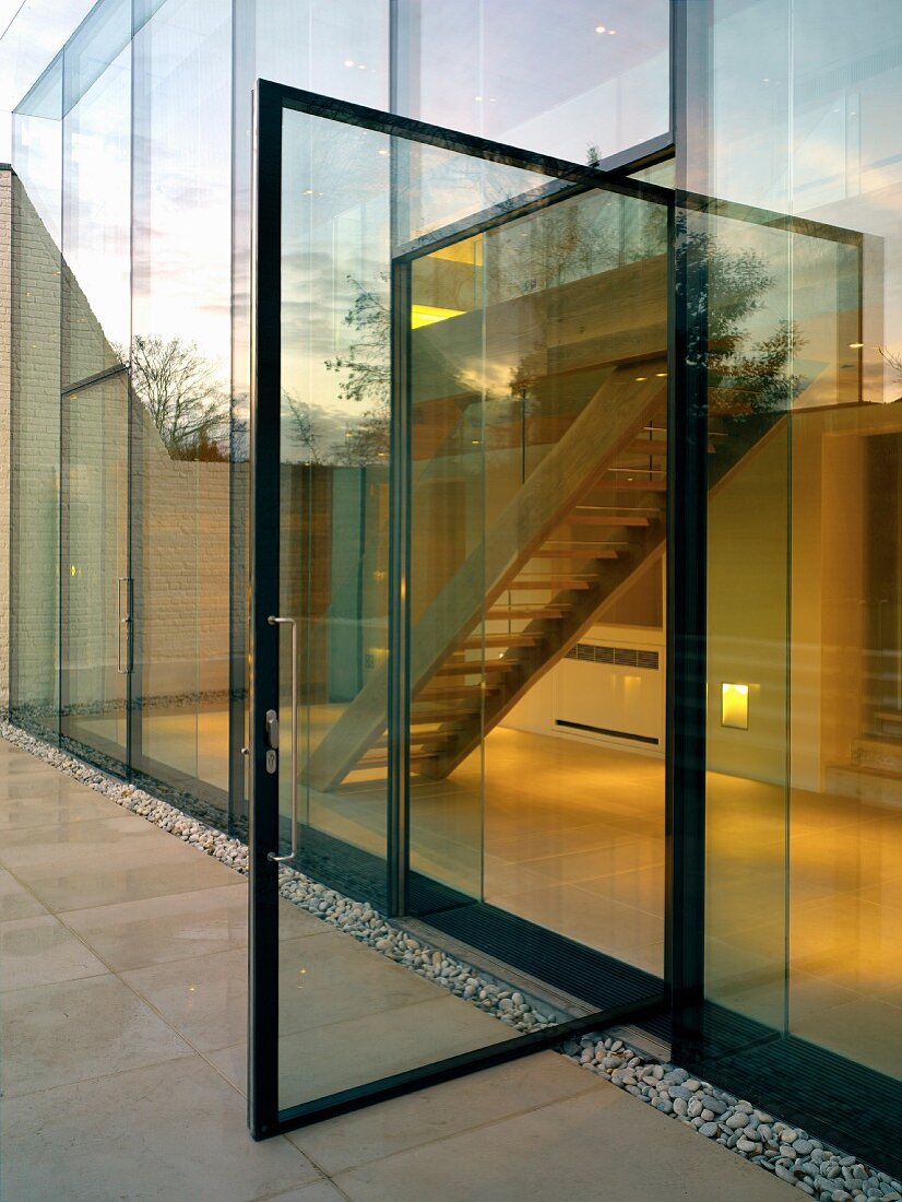 Terrasse mit offenstehender Glastür eines zeitgenössischen Wohnhauses