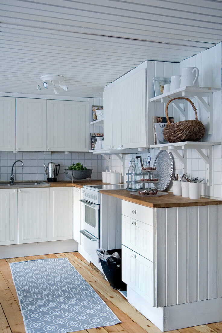 Kleine Küche im Landhausstil mit weißer Einrichtung und Holzboden