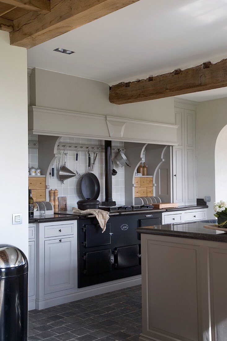 weiße Landhausküche mit schwarzem, eingebautem Retro-Ofen
