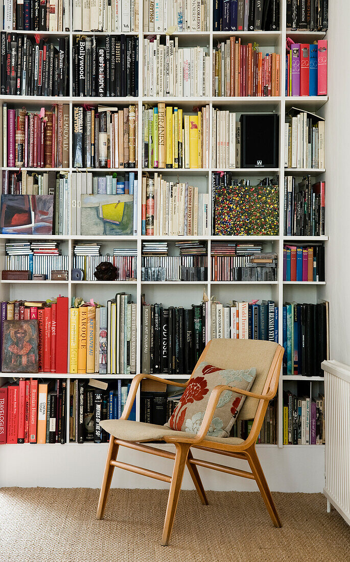 Chair with cushions in front of a full bookshelf