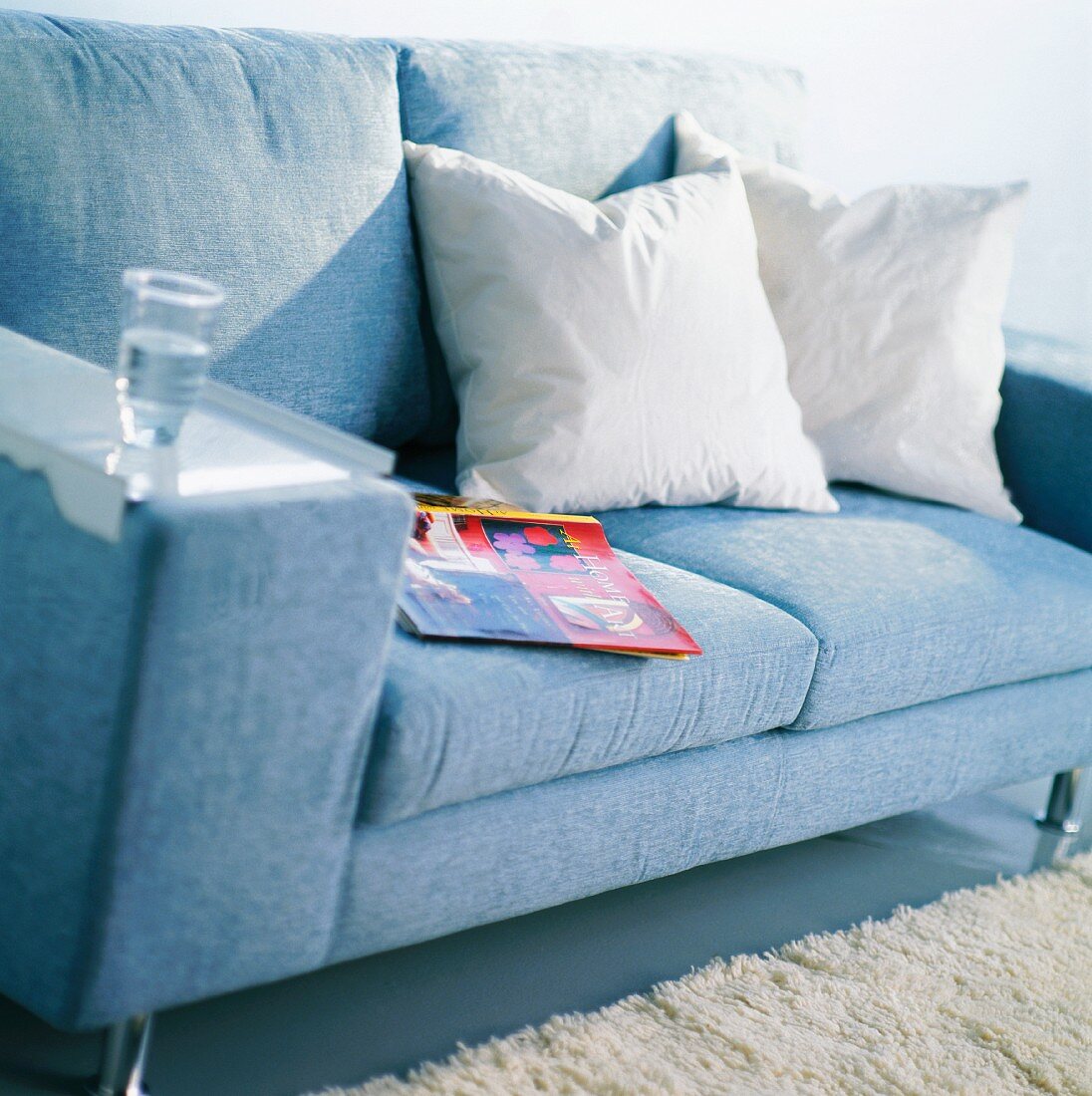 Sofa mit Kissen und einem Glas Wasser