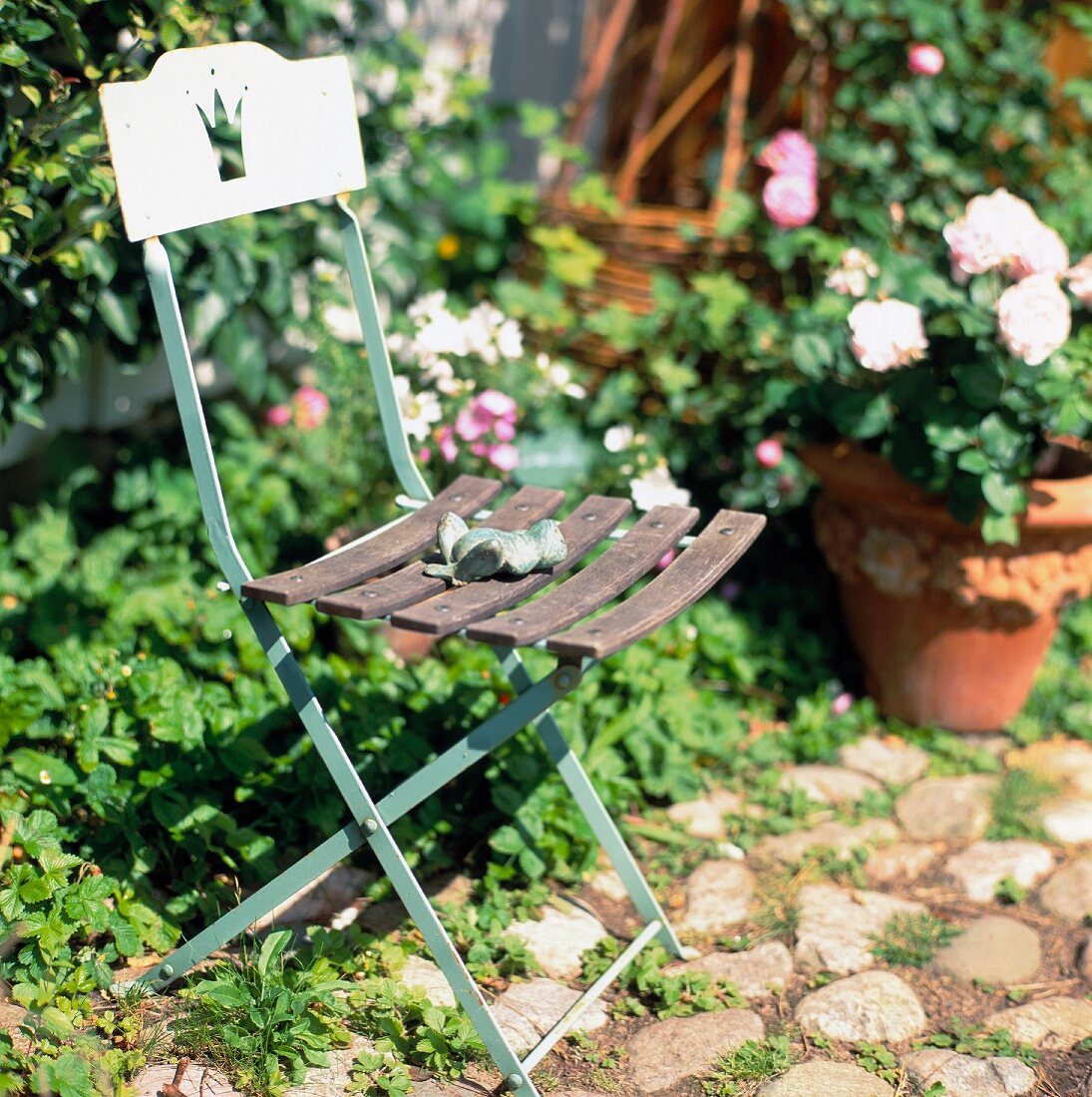 Old garden chair with frog figurine