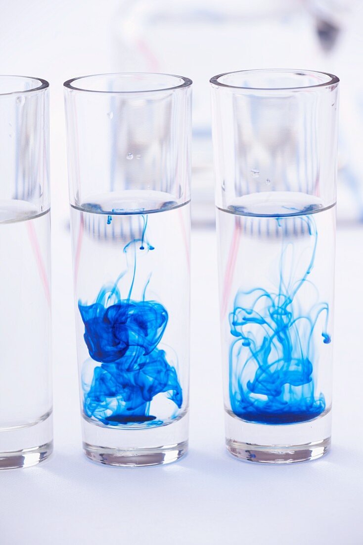 Blue colouring dispersing in glasses of water