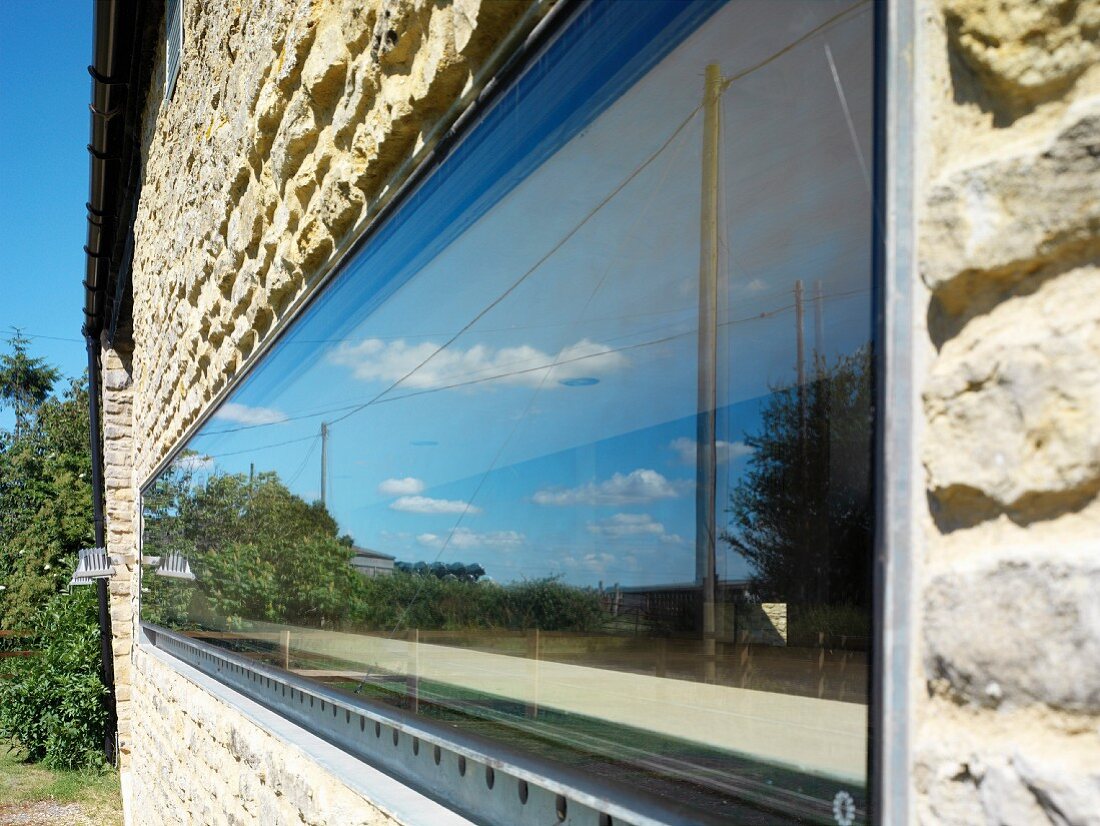 Horizontales schmales Fenster in Natursteinfassade