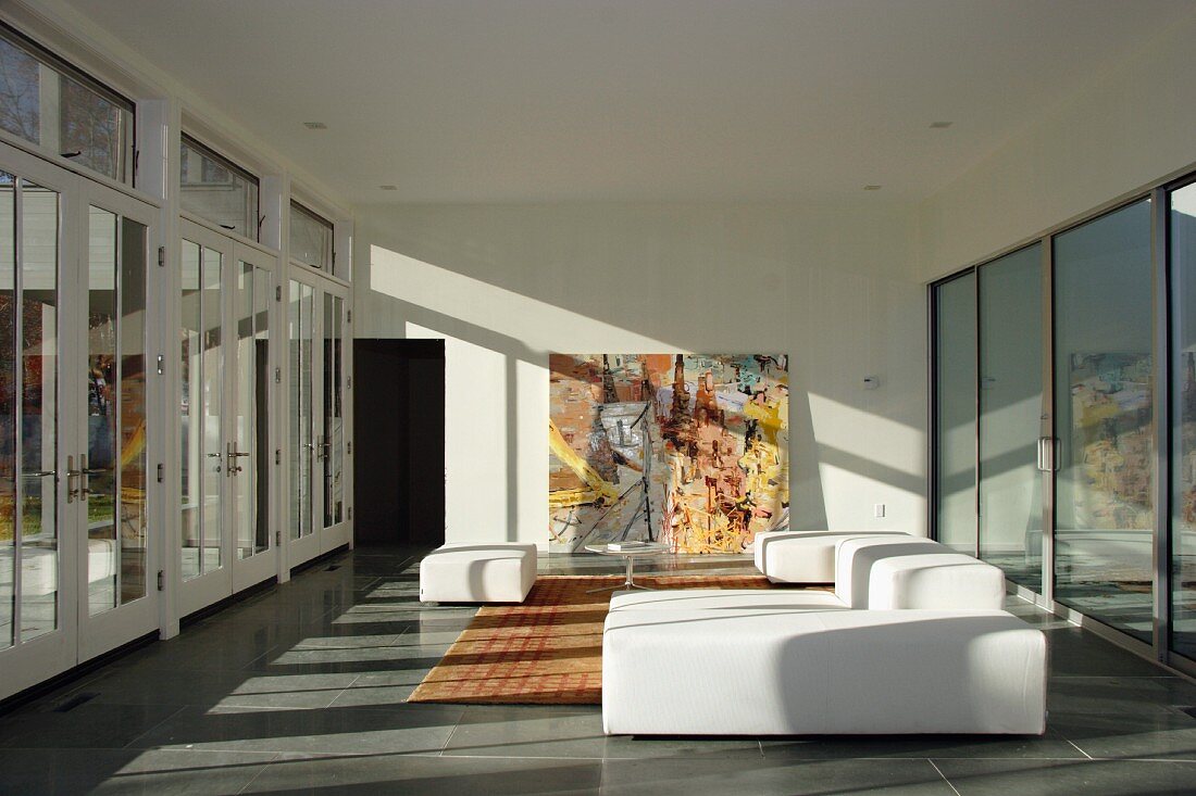 Weisses Polstersofa im minimalistischen Wohnraum mit Glasfassade
