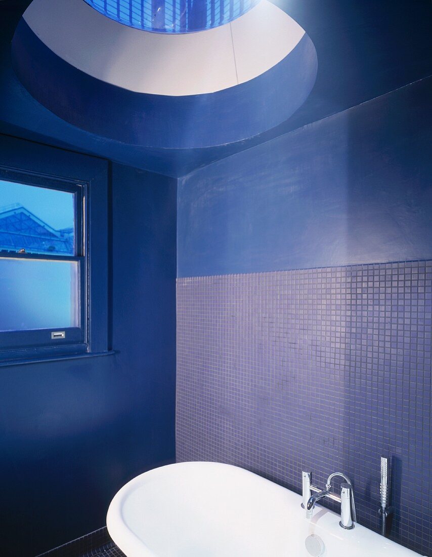 Blaugetönter Badraum mit Badewanne unter Glaskuppel