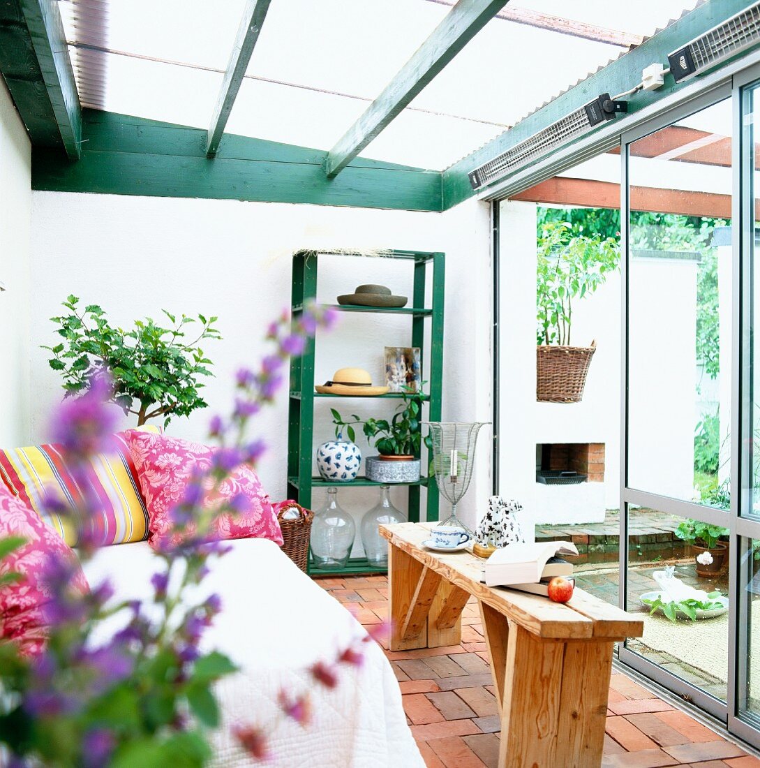 Conservatory with wooden bench, sofa and shelves