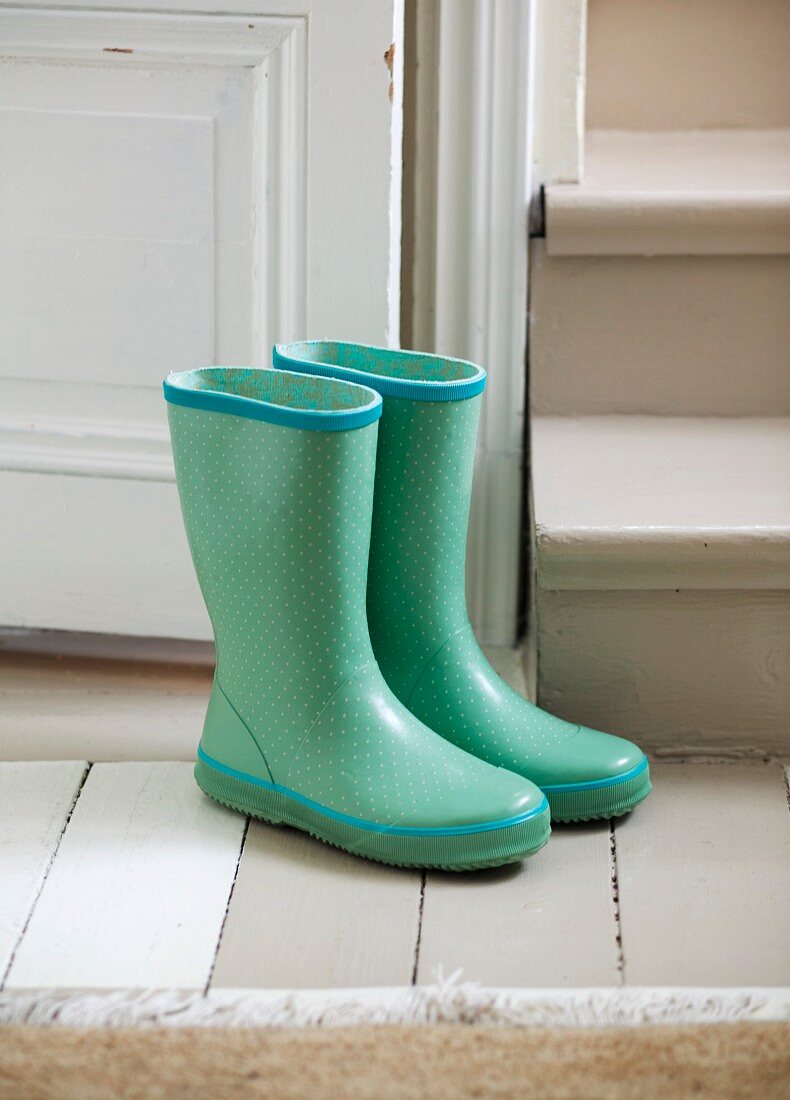 Pair of green Wellington boots next to stairs