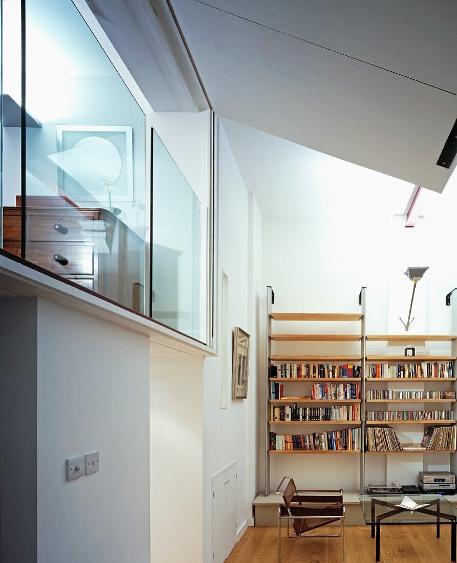 Wohnraum mit modernen Wandregalen und verglastem Schlafraum auf Galerie