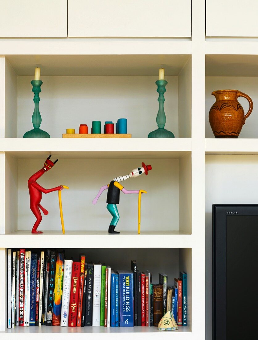 Shelves with books, figurines and candles