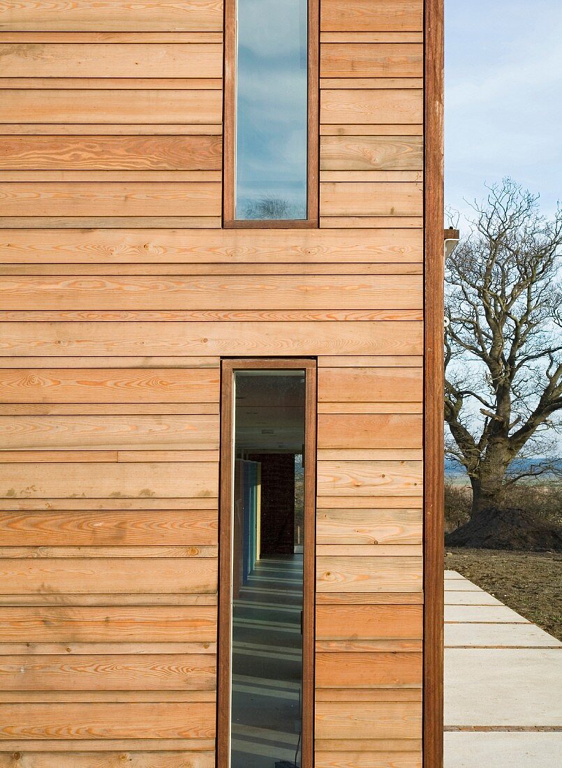 Wohnhaus mit schmalen vertikalen Fenstern in Holzfassade