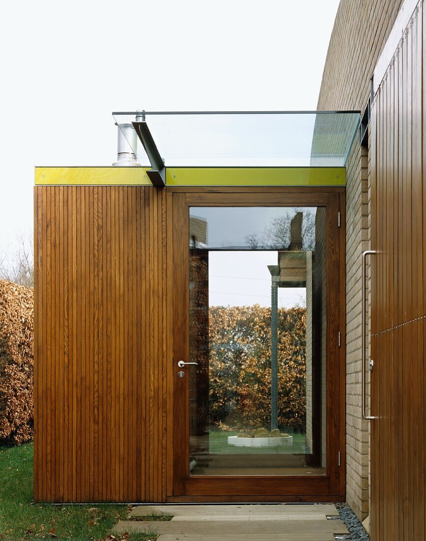 Glass front door in wood-clad porch extension