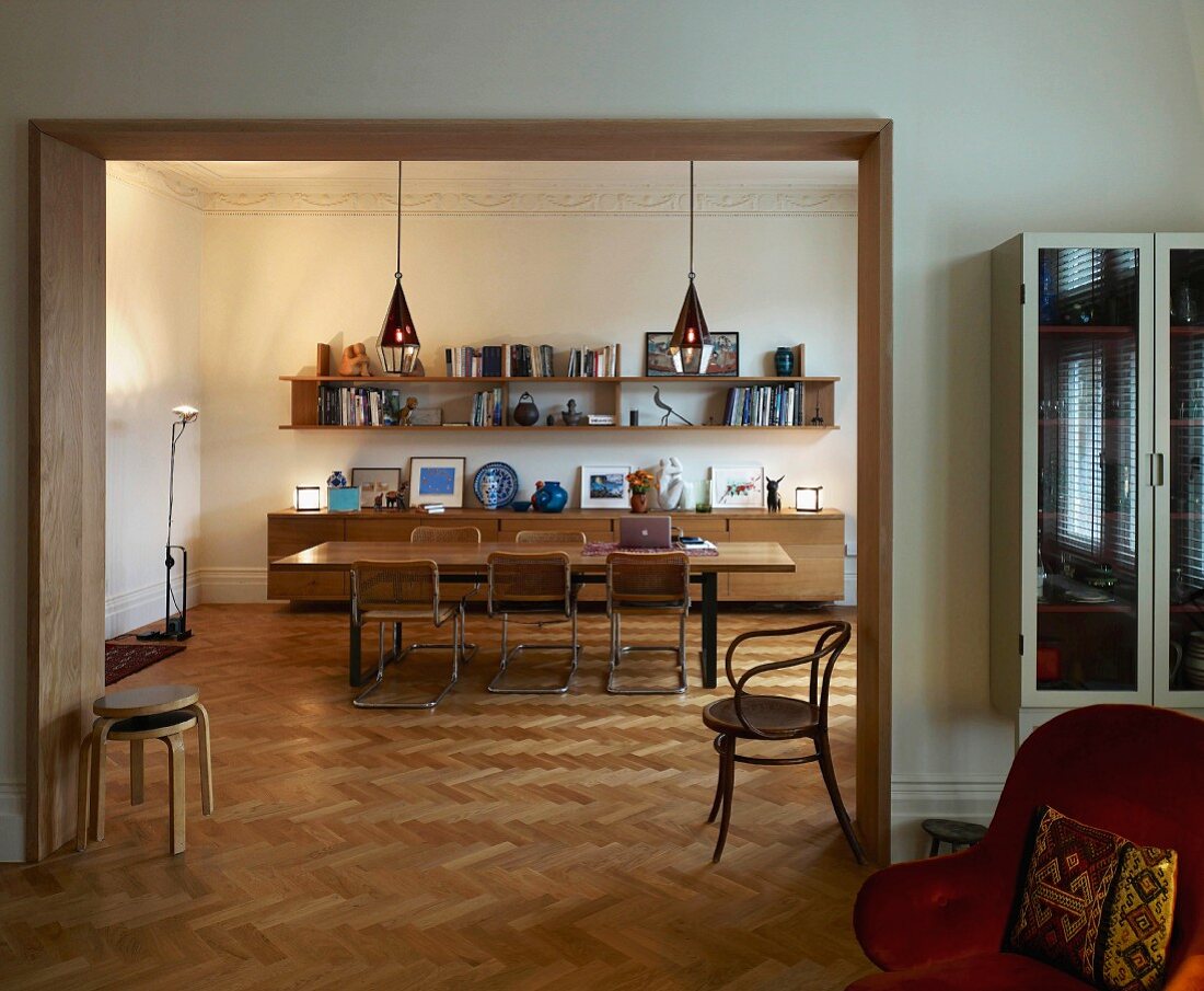 Verschiedene Stuhlklassiker im Wohnraum mit breitem Durchgang und Blick auf Essplatz