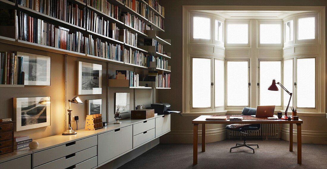 Moderne Bibliothek mit Schreibtisch vor Erker im traditionellen Stil