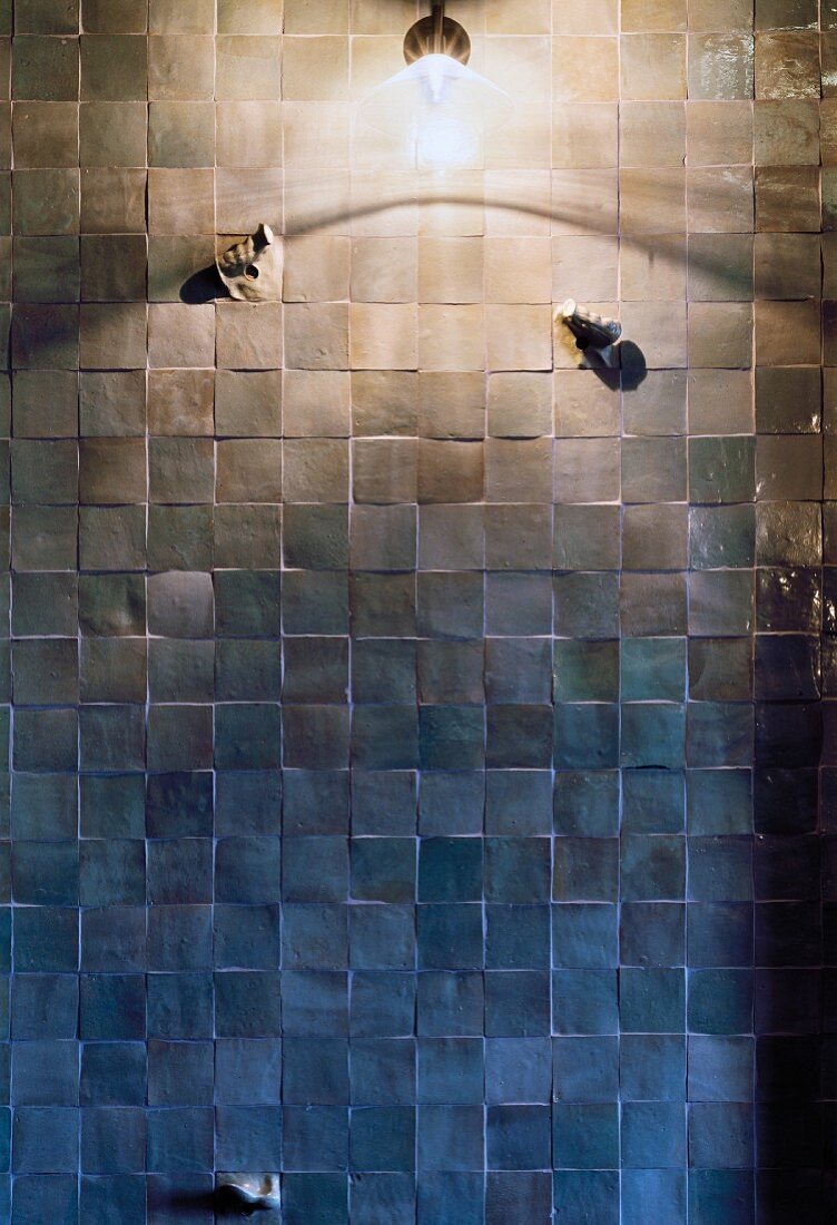 Wandlampe an gefliester Wand im Duschbereich