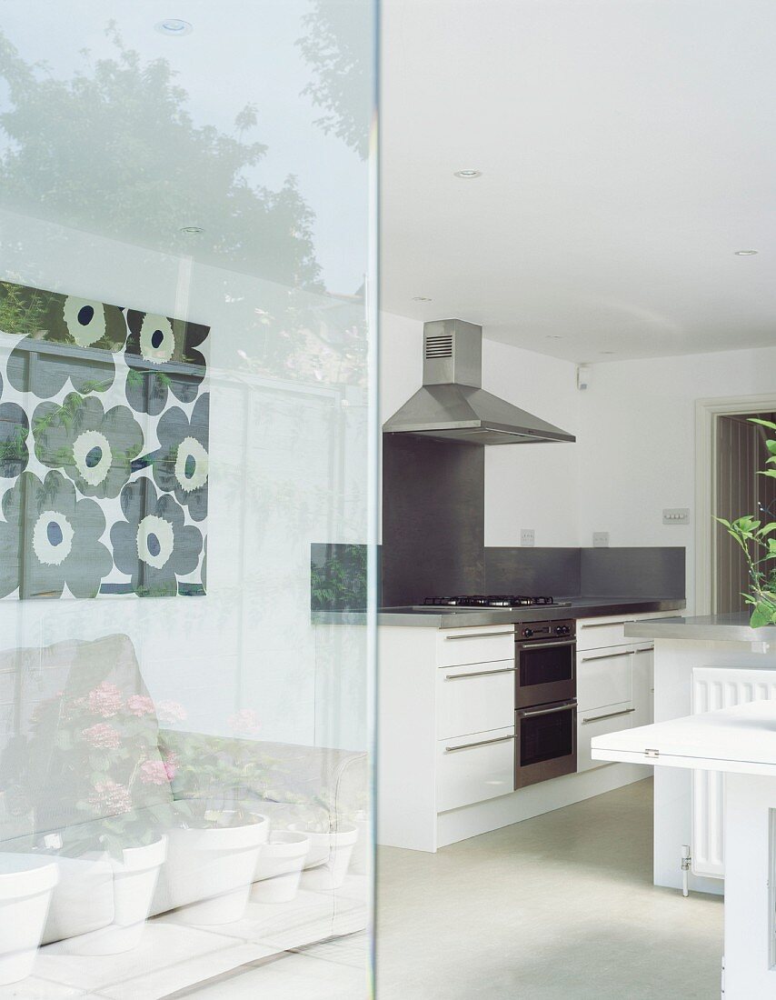 View of modern kitchen area through open glass door