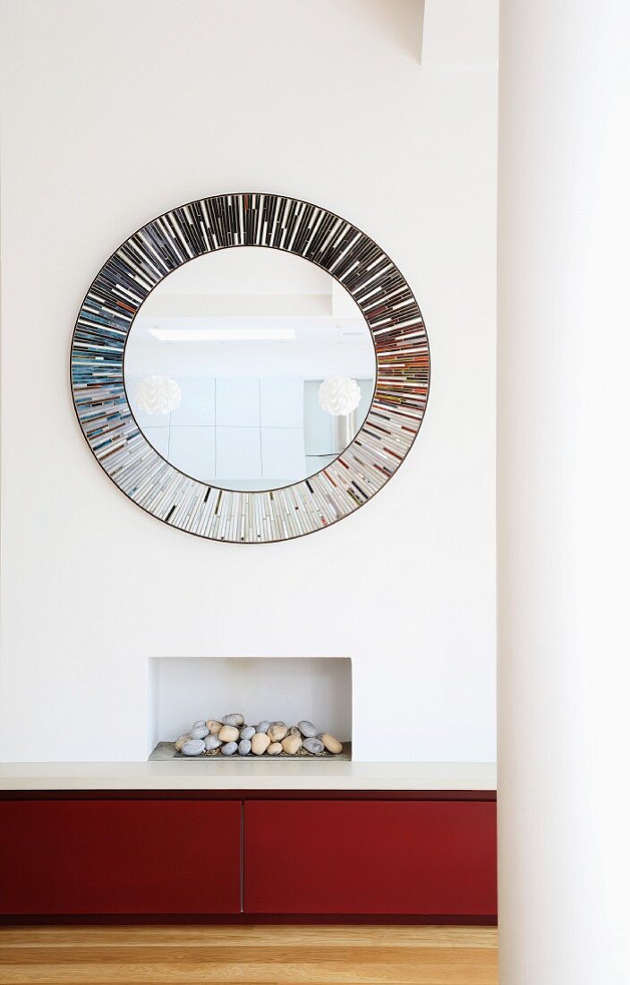 Large, round mirror hung above built-in fireplace