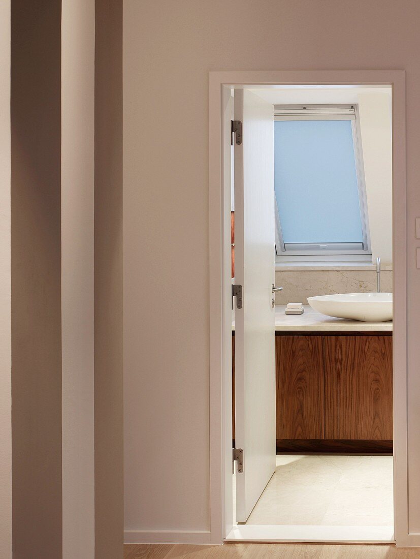 Vorraum mit geöffneter Tür und Blick ins moderne Bad