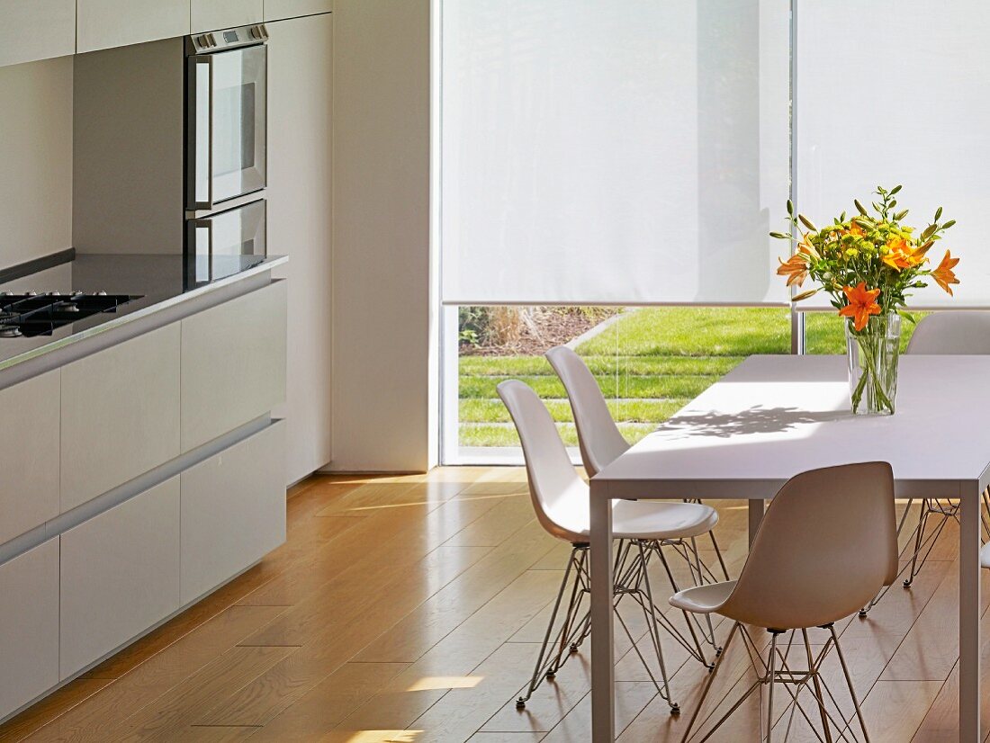 Weisser Esstisch mit Schalenstühlen in moderner Küche