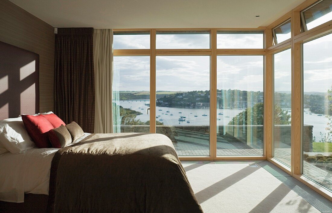 Schlafzimmer mit Glasfront und Blick auf den Fluss
