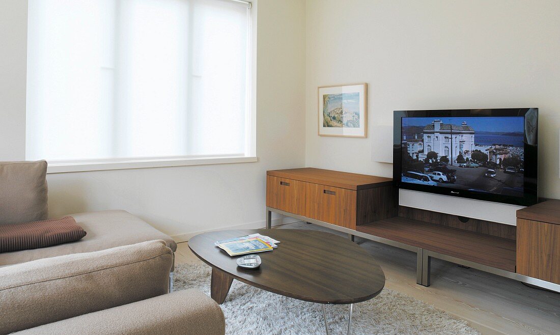 Ein Wohnzimmer mit einem flachen Fernseher an der Wand