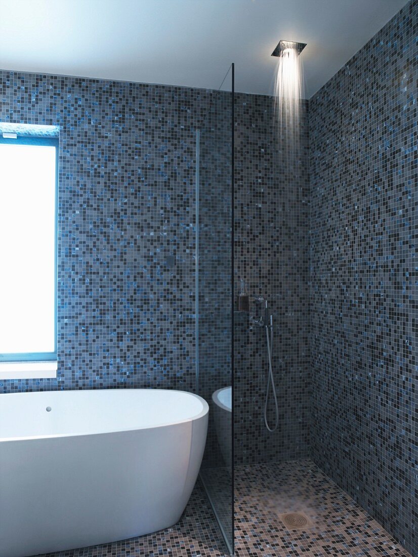 Duschbereich und Badewanne in einem Badezimmer mit Mosaikfliesen