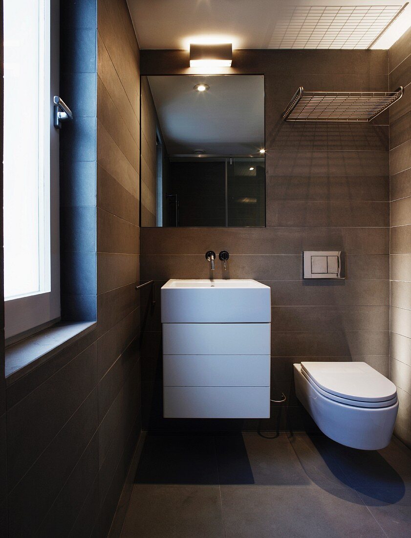 Grau gefliestes Designer Bad mit Waschtisch und Unterschrank neben Hänge-WC