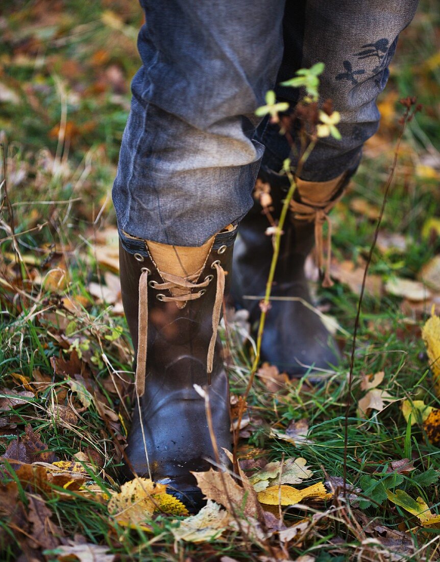 Legs with jeans and wellies in autumn garden
