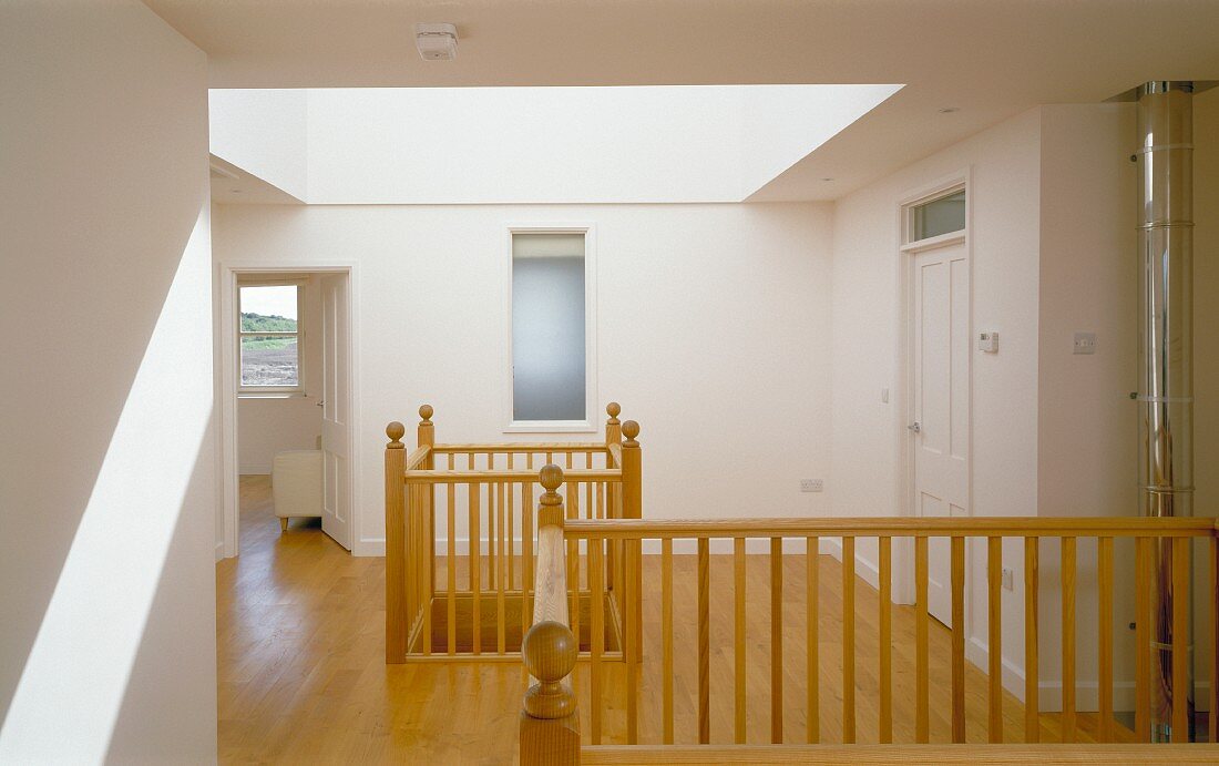 Landing with large skylight in roof and openings to lower storey with traditional wooden balustrades