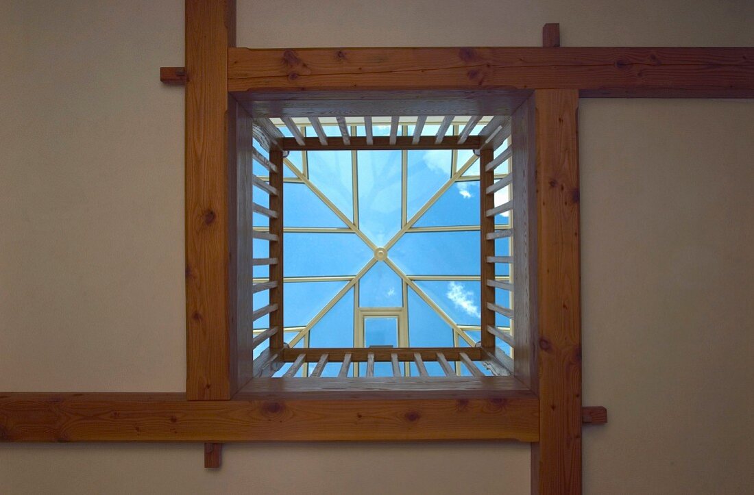 Blick in den Himmel und Licht von oben durch zeltartiges Dachfenster und Geländer umwehrte Deckenöffnung