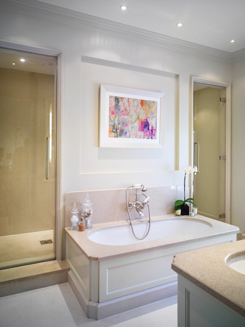 Bathtub with white-painted wood panelling in renovated bathroom