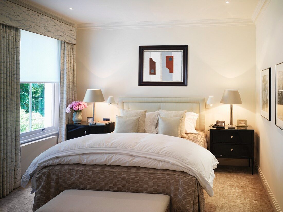Light bedroom with black bedside cabinets and white bedside lamps