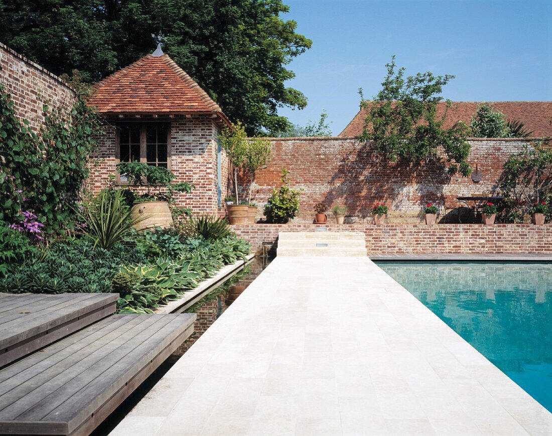Pool area with summerhouse sheltered by enclosing brick wall