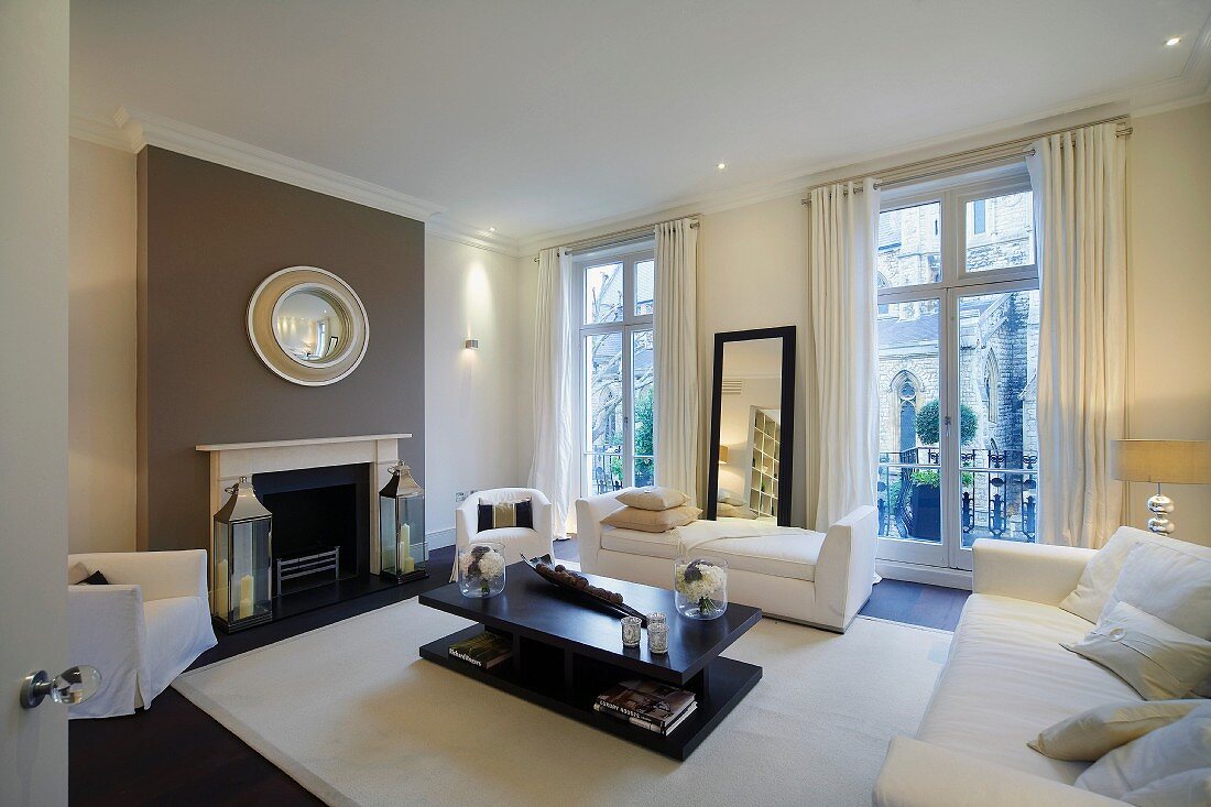 Moderne, weiße Polstermöbel und schwarzer Wohnzimmertisch in Londoner Altbau