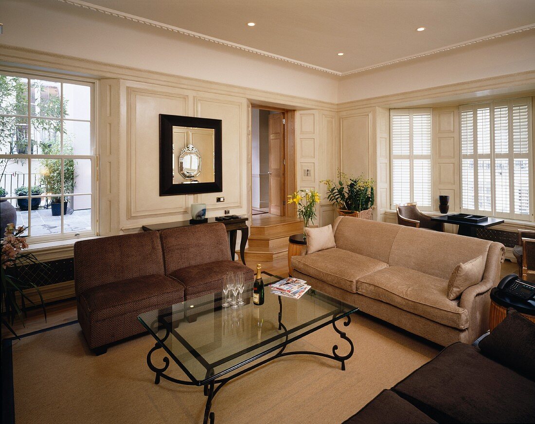 Sofas arranged around coffee table with glass top in classic living room