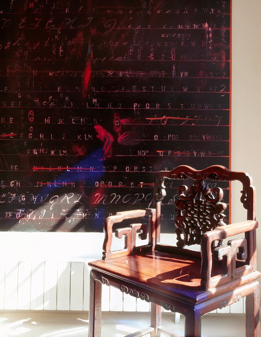 Antique chair in front of blackboard with writing on wall