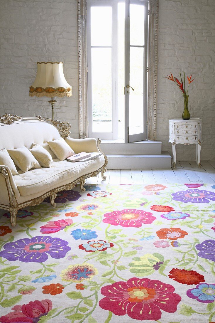 Teppich mit fröhlichem Blumenmuster vor Sofa im Rokokostil im Wohnraum