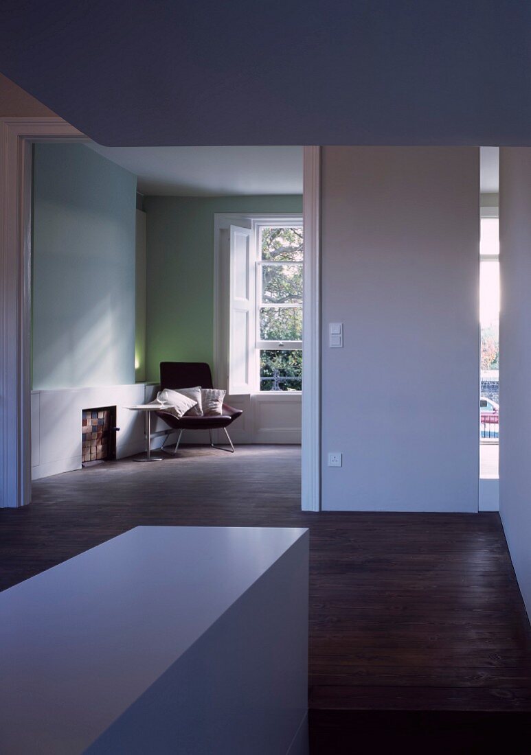 Vorraum mit breitem Durchgang und Blick in minimalistischen Wohnraum
