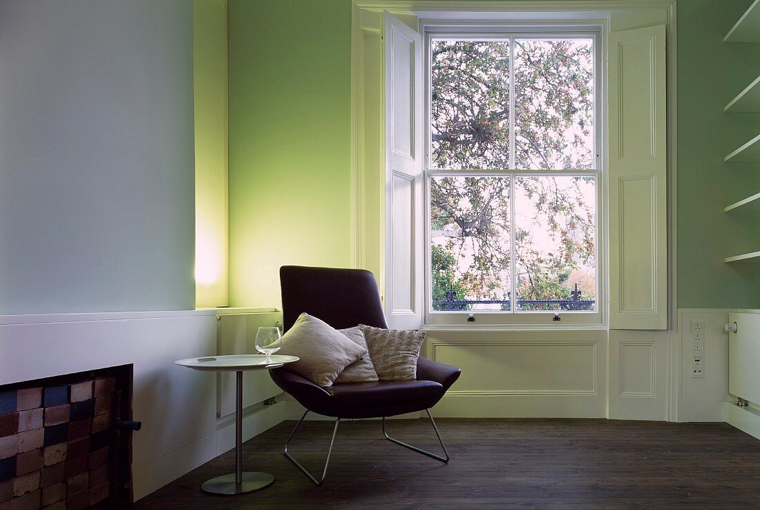 Sessel und Beistelltisch neben Fenster im minimalistischen Wohnraum mit klassischem Flair