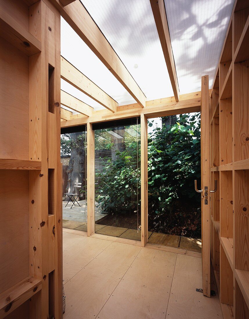 Blick in Anbau aus Holz mit offener Gartentür