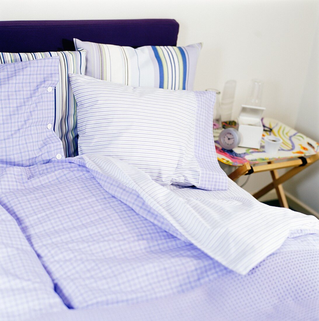 Bett mit blau-weiss gemusterter Bettwäsche