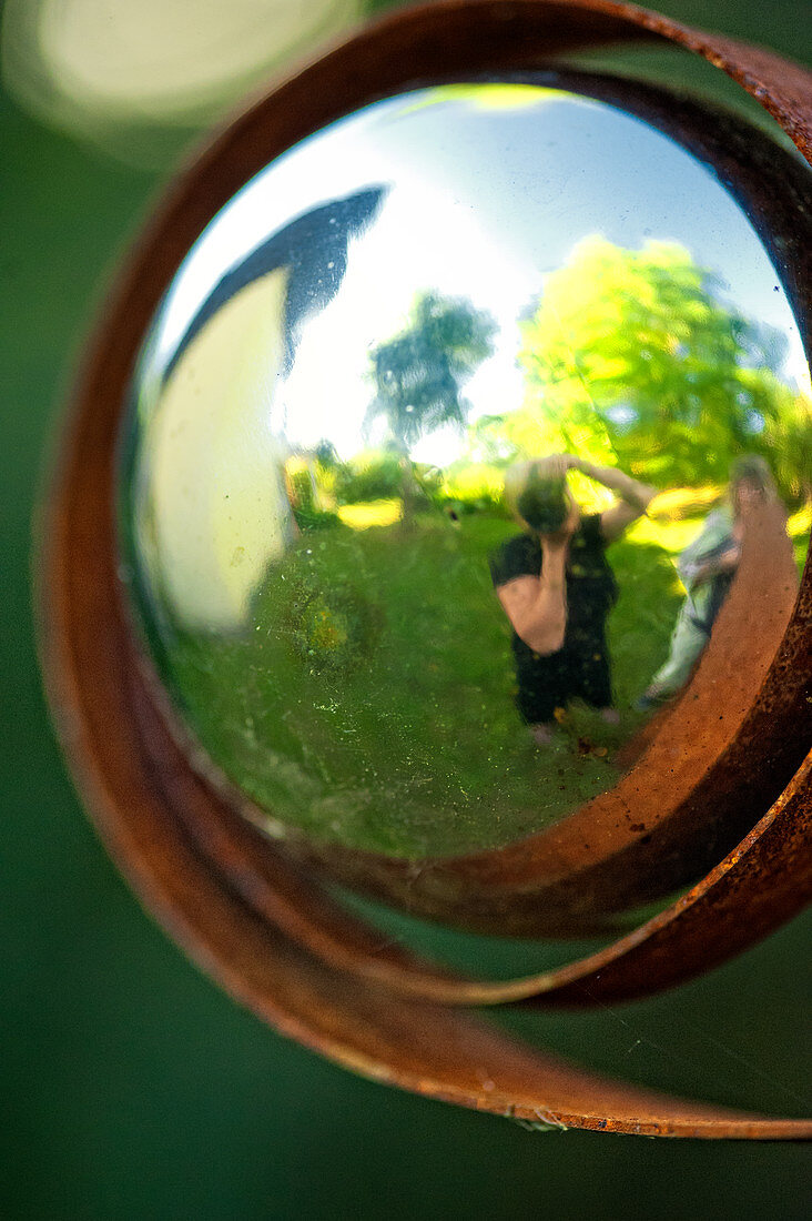 Selbstportrait in einer Metallkugel im Garten