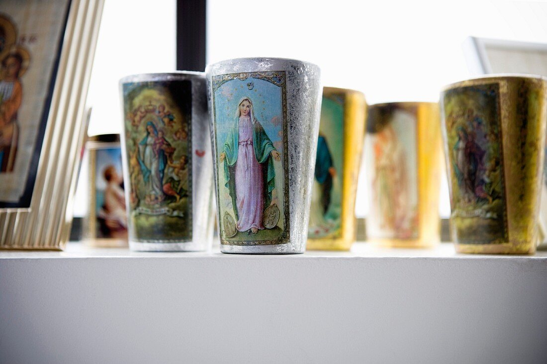 Collection of beakers with printed pictures of saints