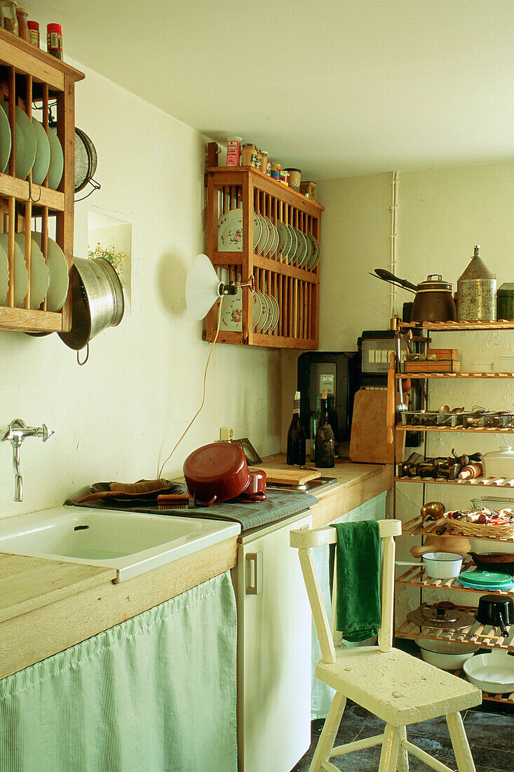 Kleine Küche mit Holzregalen und Geschirr