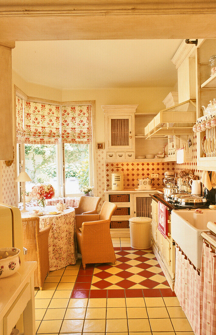 Country kitchen with floor tiles and floral curtains
