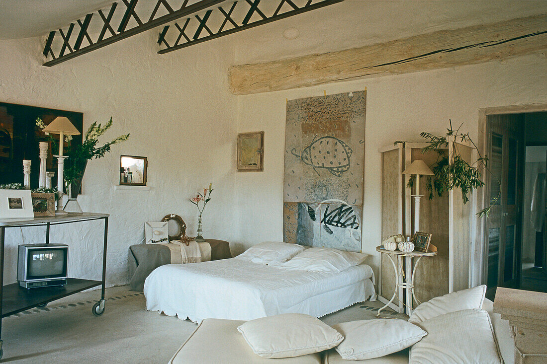 Schlafbereich mit rustikalen Balken und künstlerischem Wandbild